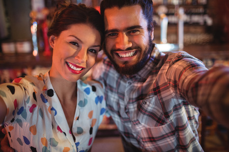 Portrait of smiling couple having fun in pubの写真素材