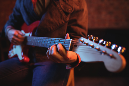 Mid-section of man playing guitar in pubの写真素材