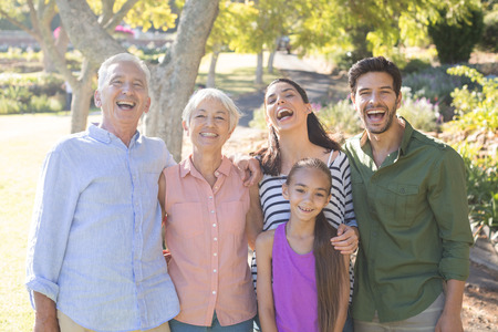 Portrait of happy family standing together in the parkの写真素材