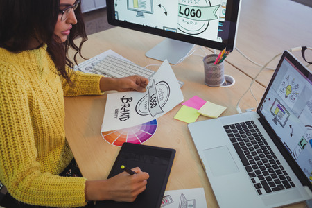 High angle view of young graphic designer working at office deskの写真素材