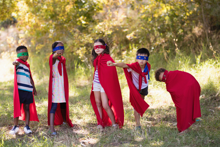 Group of friends enjoying while wearing superhero costume at campsiteの写真素材
