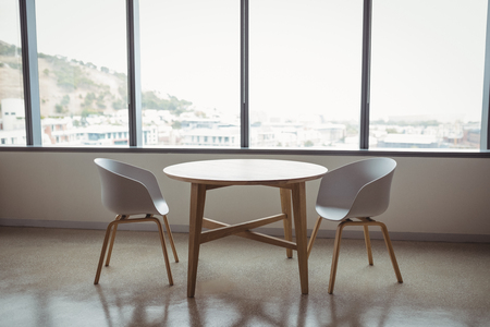 View of empty chairs and table in officeの写真素材