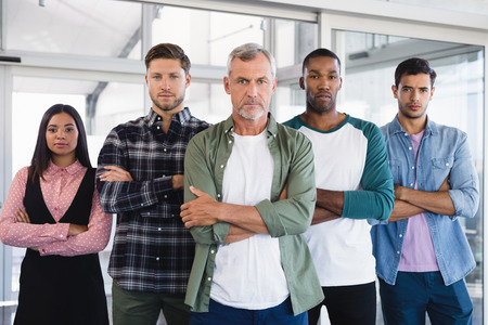 Portrait of business people with arms crossed standing in officeの写真素材