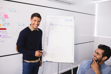 Happy male creative business colleagues in meeting room at officeの写真素材