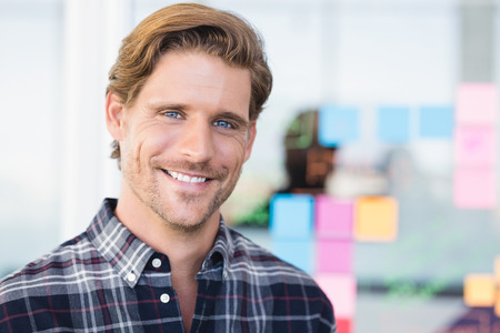 Portrait of smiling businessman standing in officeの写真素材