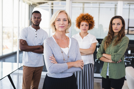 Portrait of confident business people with arms crossed standing in office