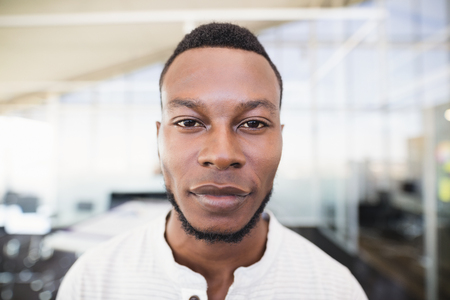 Close up portrait of businessman with stubble standing on officeの写真素材