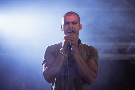 Portrait of male singer performing at nightclub during music festival