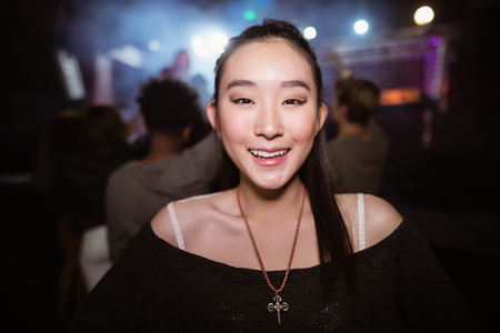 Portrait of smiling woman at nightclub during music festivalの写真素材