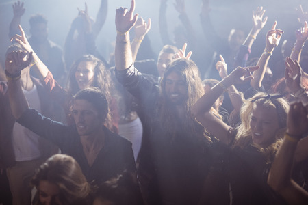 Full frame shot of cheerful fans dancing at nightclub during music festivalの写真素材