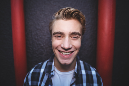 Close up portrait of smiling man standing against wallの写真素材