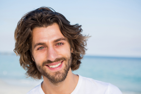 Close up portrait of young man at beach on sunny dayの写真素材