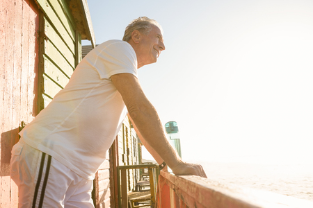 Side view of senior man leaning on railing against clear skyの写真素材