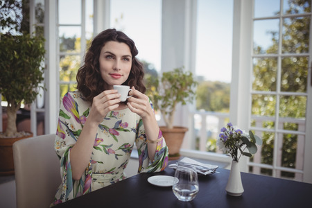 Beautiful woman having coffee in restaurantの写真素材