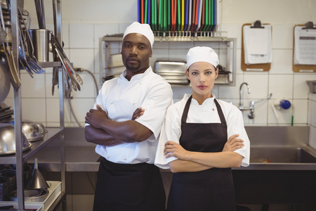 Portrait of two chefs standing with arms crossed in the commercial kitchen at restaurantの写真素材