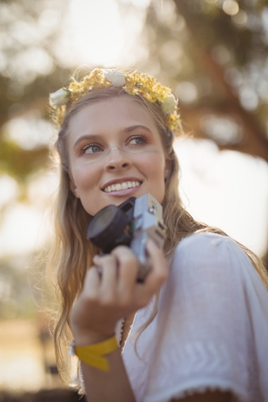 Happy young woman holding camera
