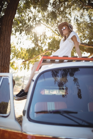 Full length of young woman relaxing on vanの写真素材