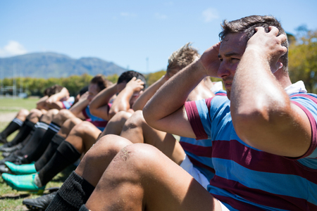 Close up of rugby players exercising on fieldの写真素材