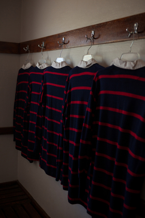 Rugby shirts hanging from clothes rack in roomの写真素材