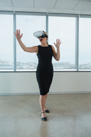 Young female executive using virtual reality headset in officeの写真素材
