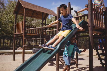 Kids playing on slide at school playgroundの写真素材