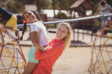 Portrait of happy trainer and girl having fun at school playgroundの写真素材