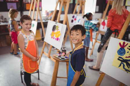 Portrait of happy schoolkids practicing drawingの写真素材