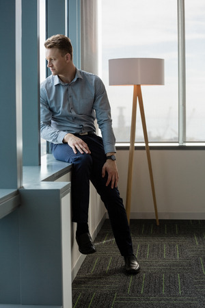 Thoughtful executive looking through window in office