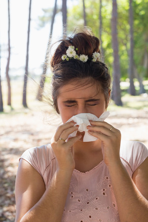 Woman suffering from cold and flu in the parkの写真素材
