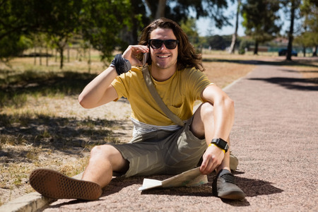 Tourist man with map talking on mobile phone in the park