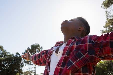 Blissful man standing with arms outstretched in the parkの写真素材