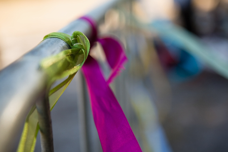 Decorative ribbons tied on a railing in the parkの写真素材