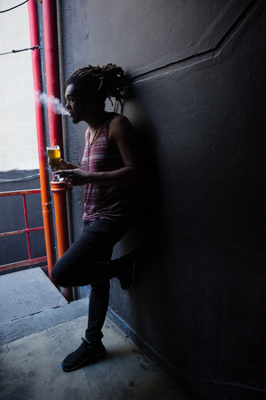 Man smoking while having beer at the entrance of barの写真素材