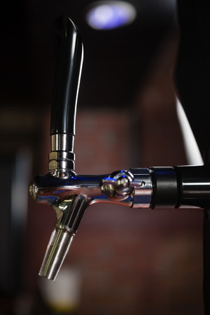 Close-up of beer dispenser tap in bar