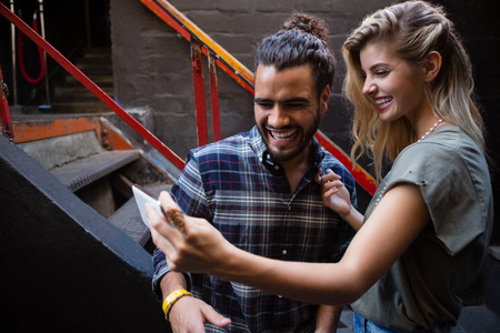 Couple taking selfie on mobile phone outside the barの写真素材