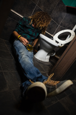 Unconscious man sleeping in the washroomの写真素材