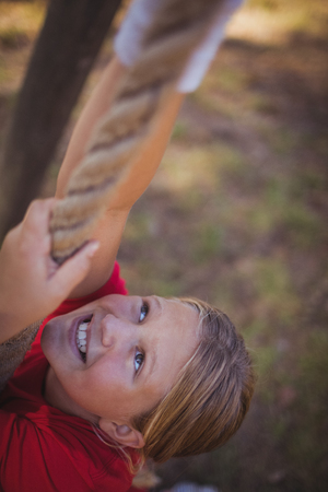 Girl climbing a rope during obstacle course training in the boot campの写真素材