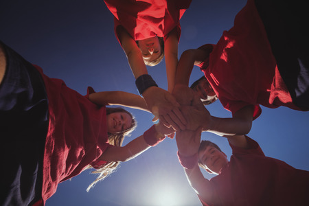 Kids forming hand stack in the boot camp on a sunny dayの写真素材