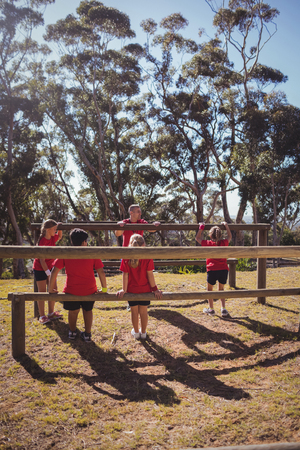 Trainer instructing kids during obstacle course training in the boot campの写真素材