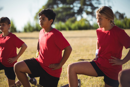 Group of kids exercising in the boot camp on a sunny dayの写真素材