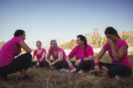 Female trainer instructing women while exercising in the boot camp on a sunny dayの写真素材