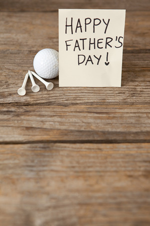 High angle view of fathers day greeting card and golf ball on wooden tableの写真素材