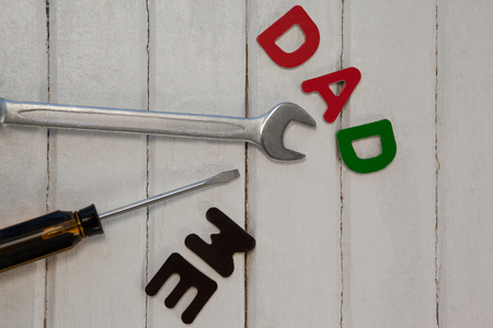 Overhead view of text with hand tools on wooden tableの写真素材