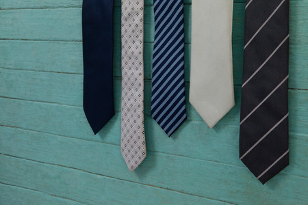 Close up of various neckties hanging by green wooden wallの写真素材
