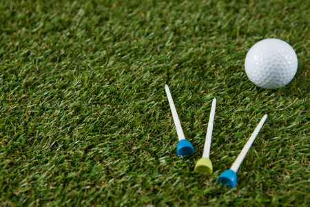 High angle view of golf ball with tee at grassy field
