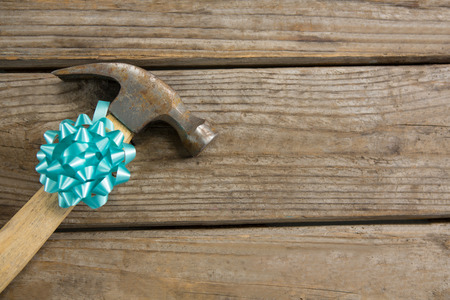 High angle view of hammer decorated with ribbon on wooden tableの写真素材