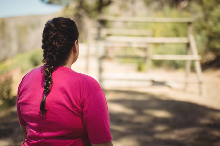 Rear view of woman standing in boot camp during obstacle course