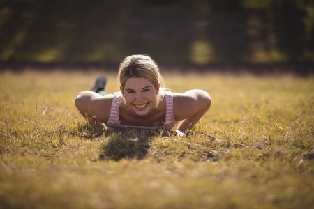 Portrait of happy woman exercising during obstacle course in boot camp