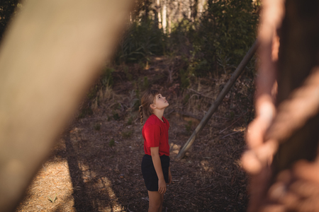 Determined girl looking at outdoor equipment during obstacle course in boot campの写真素材