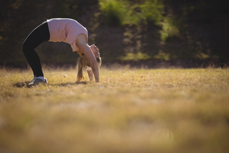 Woman performing stretching exercise during obstacle course in boot campの写真素材